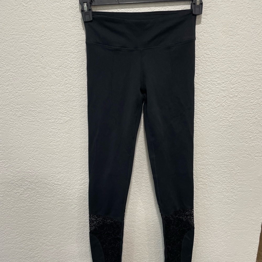 Black FABLETICS leggings with lace flower detail on the bottom of both legs!